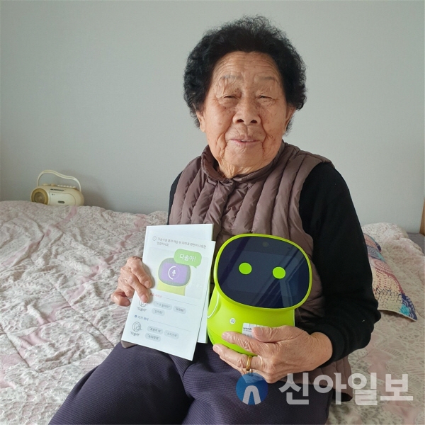 한 할머니가 AI 다솜이를 품에 안고 편안한 표정을 짓고 있다. (사진=철원보건소)