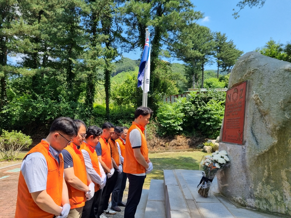 한화오션 직원들이 24일 경기도 가평군에 위치한 뉴질랜드 전투기념비에 환경정화 활동을 하고 헌화 묵념하고 있는 모습.[사진=한화오션]