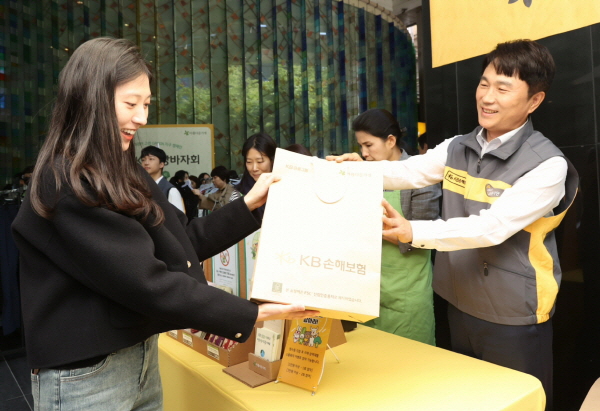 구본욱 KB손해보험 사장(오른쪽)이 16일 서울 강남구 본사에서 열린 'KB희망바자회'에서 구매 고객에 물건을 건내고 있다. (사진=KB손해보험)