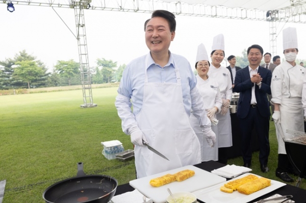 윤석열 대통령이 24일 서울 용산 대통령실 청사 잔디마당에서 열린 ‘대통령의 저녁 초대’ 출입기자단 초청 만찬 간담회에서 계란말이를 만들고 있다. (사진=대통령실)