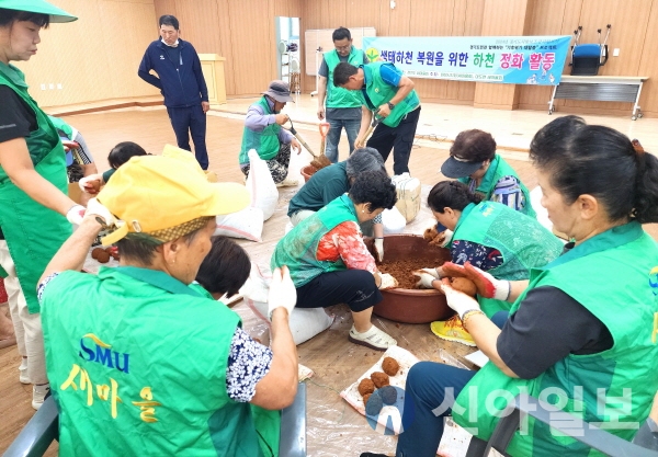 화성시 마도면새마을회가 최근 하천 정화활동의 일환으로 EM흙공을 만들고 있다. (사진=마도면새마을회)