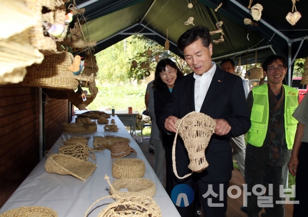 사진 밀양시( 안병구 밀양시장이 29일 주민총회장 앞에서 짚풀공예를 둘러보고 있다)