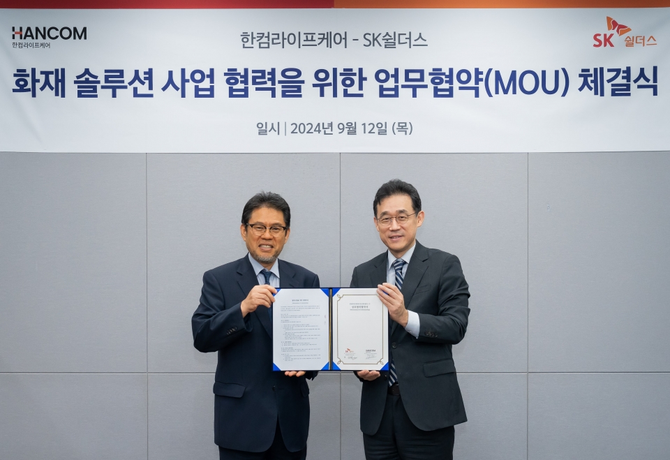 지난 12일 SK쉴더스 판교본사에서 SK쉴더스와 한컴라이프케어가 전기차 및 리튬 배터리 화재 예방 시스템 구축을 위한 협력을 진행했다. SK쉴더스 김진중 융합보안사업부장(전무, 오른쪽)과 한컴라이프케어 오병진 대표(왼쪽)가 기념 촬영을 하고 있다.[사진=SK쉴더스]