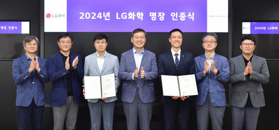 LG화학 명장으로 선발된 고영춘 전문과장(왼쪽 3번째), 성기욱 계장(오른쪽 3번째)과 LG화학 신학철 부회장(가운데)이 LG화학 명장 인증식을 진행하고 기념촬영을 하고 있다. [사진=LG화학]