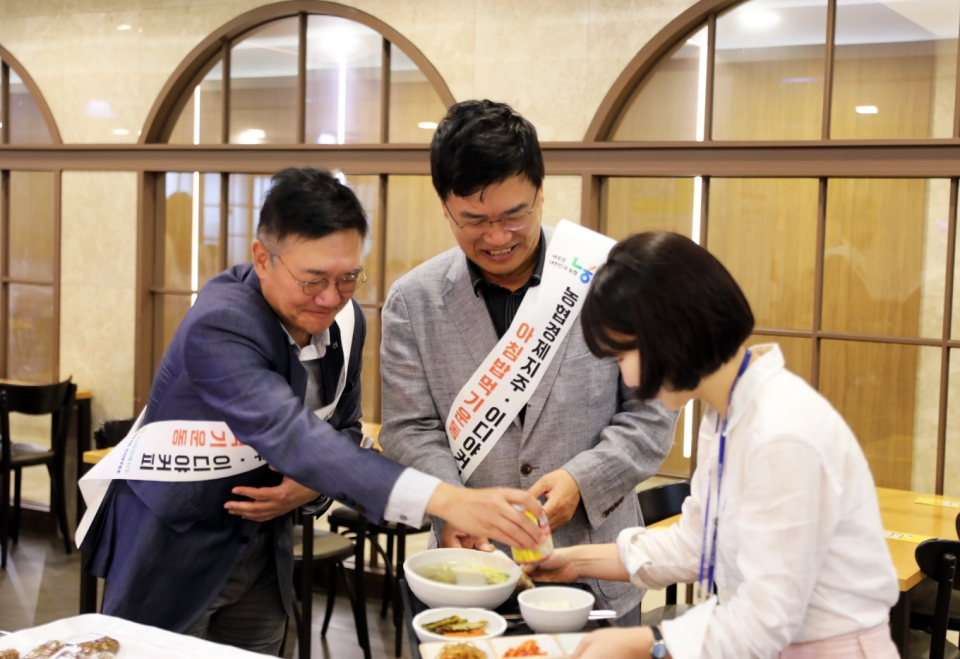 30일 서울 강남구 이디야커피 본사에서 문창기 회장(가운데)과 이천일 농협경제지주 경제기획본부장(왼쪽)이 한 직원에게 ‘아침밥 먹기 운동’ 캠페인을 소개하고 있다. [사진=이디야커피]