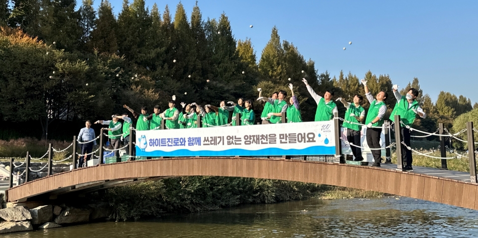 30일 하이트진로 서초본사 인근 양재천에서 임직원 20여명이 환경보호 차원의 ‘EM흙공 던지기' 활동을 하고 있다. [사진=하이트진로]